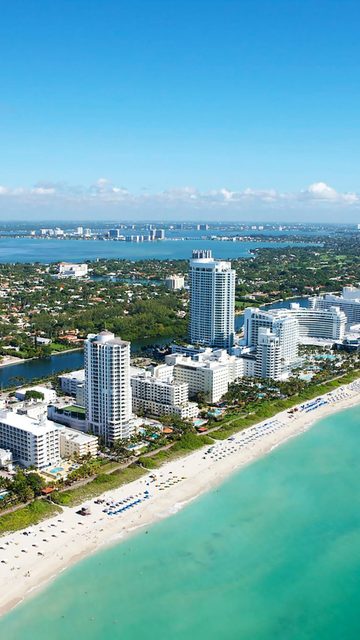 Aerial view of stunning buildings next to a white beach at Miami Beach ...