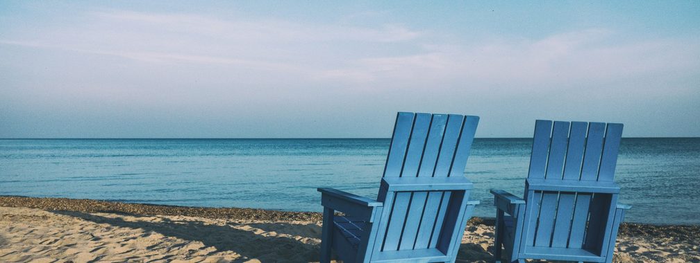 Adirondack chairs on the sandy beach