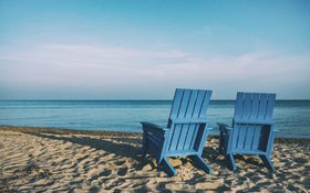 Adirondack chairs on the sandy beach