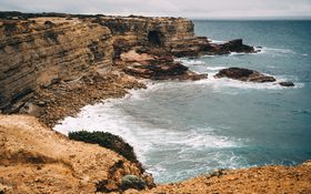 Aerial view of ocean crashing on the rocks in Faro District, Portugal