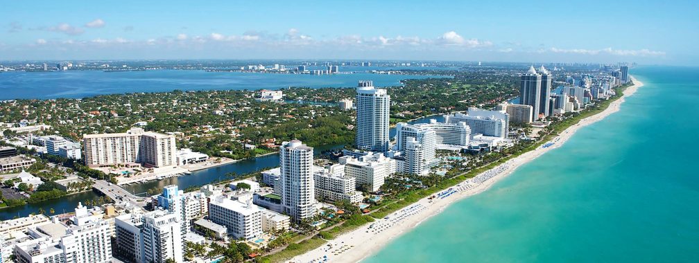 Aerial view of stunning buildings next to a white beach at Miami Beach, FL, USA