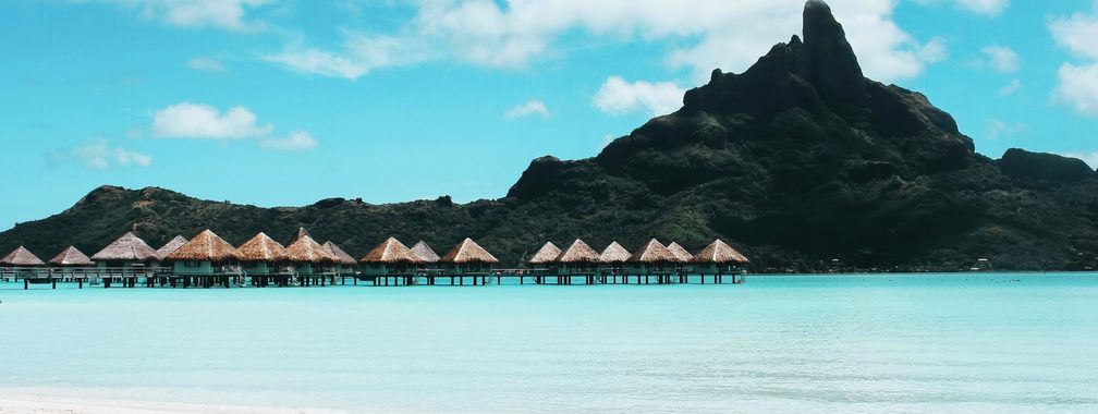 Charming tropical island with cottages and beach chairs in French Polynesia