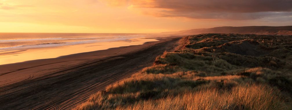 Cloudy sunset over the sand dunes in Port Waikato, New Zealand
