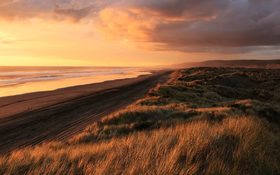 Cloudy sunset over the sand dunes in Port Waikato, New Zealand