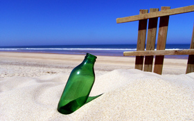 Green bottle on sandy beach wallpaper