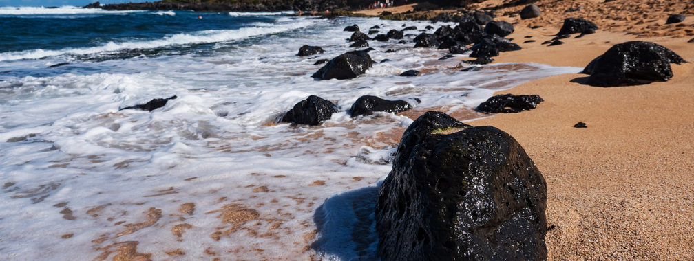 Ocean waves crashing on lava rocks on Ho’okipa Beach in Maui, Hawaii