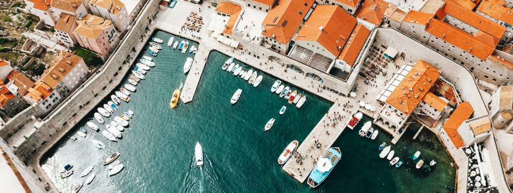 Old city port with moored ships and historical houses in Dubrovnik, Croatia