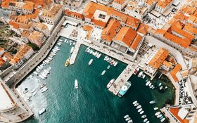 Old city port with moored ships and historical houses in Dubrovnik, Croatia