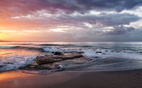 Stormy orange beach sunrise at Playa de la Misericordia, Spain