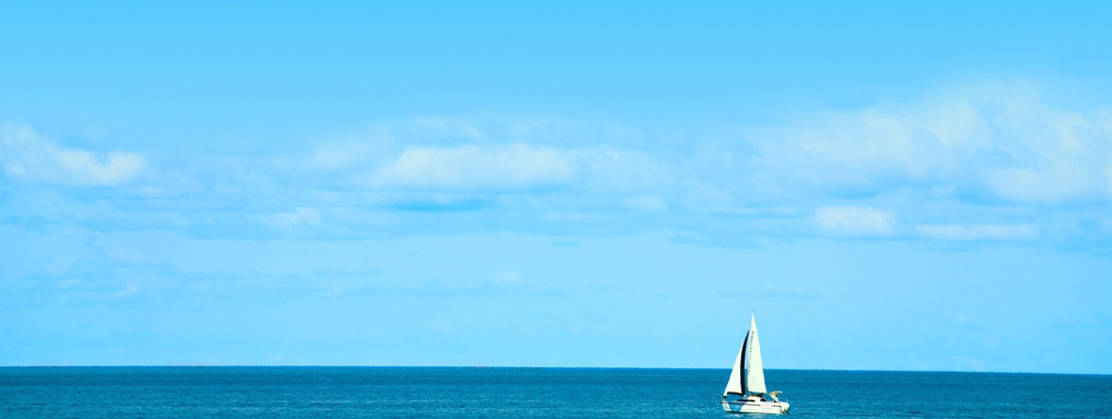 White Sailboat on Blue Ocean Beach Background